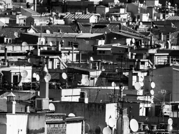 Fotografía en blanco y negro de los tejados de Barcelona con antenas y azoteas vista desde un edificio