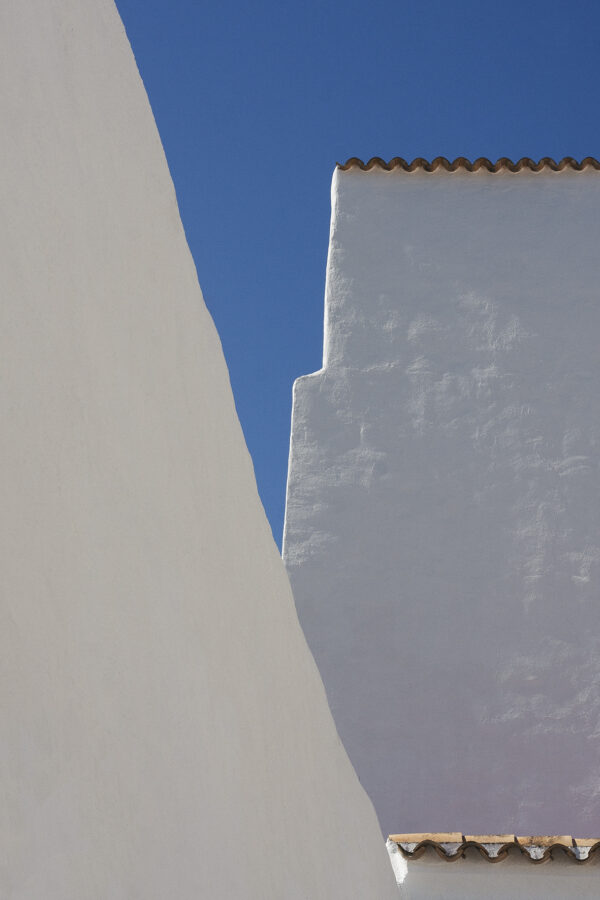 Arquitectura tradicional de Ibiza, paredes de cal blanca bajo el cielo azul – fotografía minimalista fine art de Marco Lo Piccolo